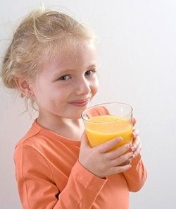 Девочка пьет апельсиновый сок