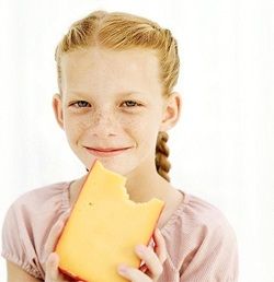 Девочка ест сыр